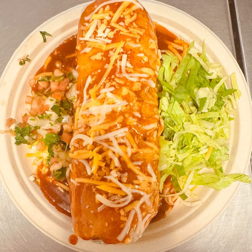 Eduardos Taco Shop's wet burrito, smothered in red sauce and cheese, with a side of pico de gallo and lettuce.